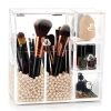 A chic acrylic makeup brush holder with a dustproof lid, pink pearl beads, and two compartments for storing brushes and beauty essentials.